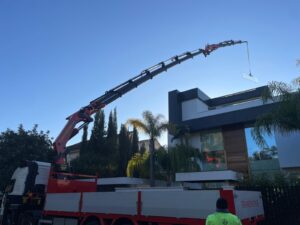 Grua 85 tn mas jib colocando cristal en la trasera de la vivienda