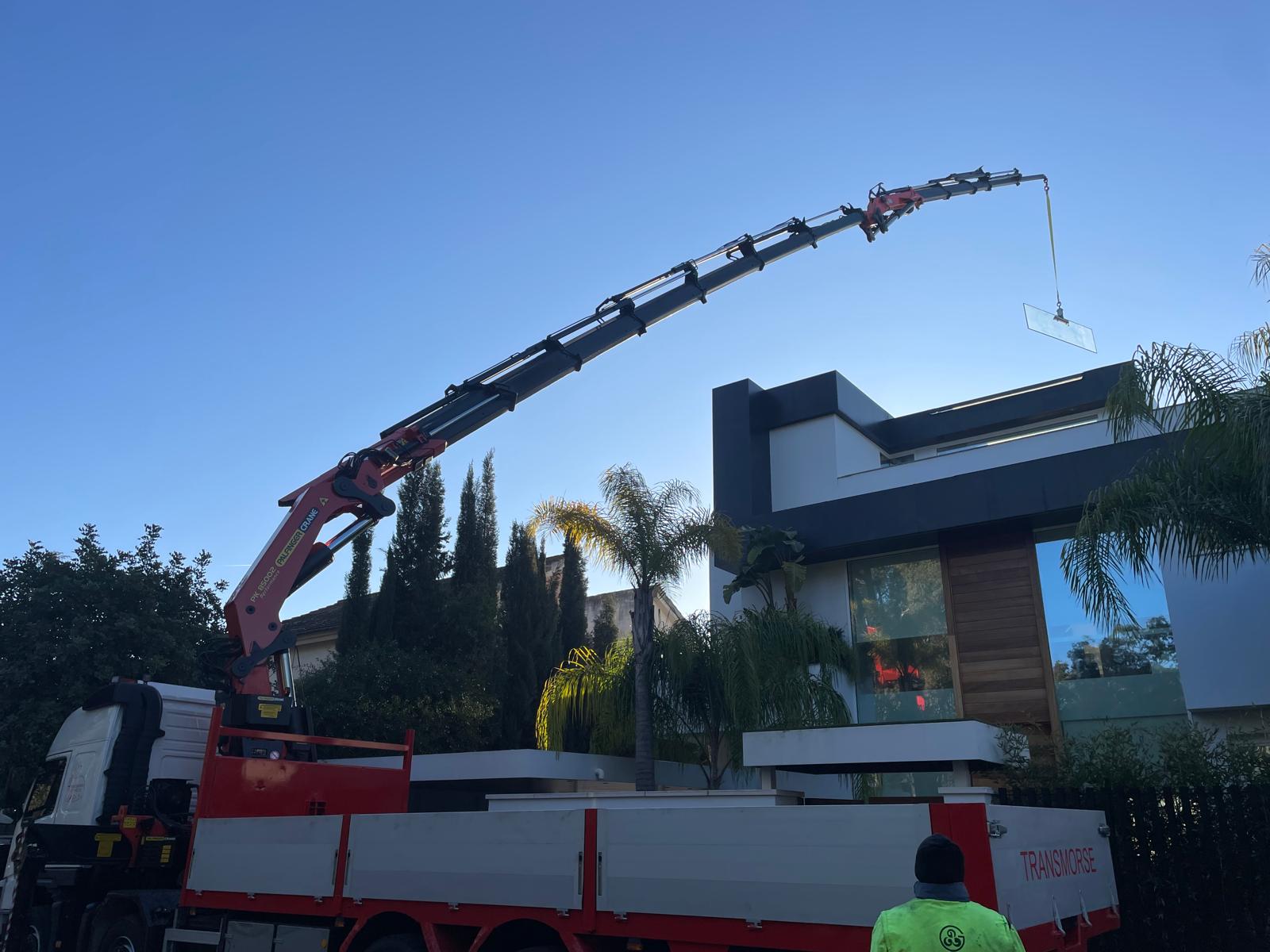 Grua 85 tn mas jib colocando cristal en la trasera de la vivienda